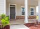 Covered front porch with stone accents and white columns, ideal for enjoying the outdoors at 730 Autumn Sage Dr, Indian Trail, NC 28079