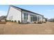 White modern home with a well-maintained lawn and covered outdoor seating area at 82116 Standing Oak Dr, Charlotte, NC 28278