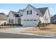 Beautiful white home with a three car garage, well-manicured lawn, and lovely landscaping at 82116 Standing Oak Dr, Charlotte, NC 28278