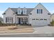 Charming white home features a manicured lawn, a two car garage and classic black window shutters at 82116 Standing Oak Dr, Charlotte, NC 28278