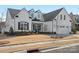 Angle view of a white home featuring a two car garage and a landscaped lawn with bare tree at 82116 Standing Oak Dr, Charlotte, NC 28278