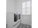 White laundry room featuring patterned tile flooring and two modern washing machines at 82116 Standing Oak Dr, Charlotte, NC 28278