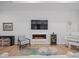 Spacious living room with a fireplace, large TV, hardwood floors, and piano at 82116 Standing Oak Dr, Charlotte, NC 28278