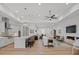 Spacious open-concept living room with a fireplace, modern kitchen, light wood floors, and white walls at 82116 Standing Oak Dr, Charlotte, NC 28278
