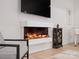 Bright living room features a modern fireplace, mounted television, light wood floors, and decorative accents at 82116 Standing Oak Dr, Charlotte, NC 28278
