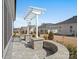 Beautiful outdoor patio with stone seating, overhead pergola, and manicured landscaping at 82116 Standing Oak Dr, Charlotte, NC 28278