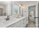 Double sink bathroom, white cabinets, stylish lighting, and an open view into the main bedroom at 901 Cathey Rd, Charlotte, NC 28214