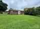 Spacious backyard with lush lawn surrounding a single-story brick home with a deck at 948 Shannon Bradley Rd, Gastonia, NC 28052