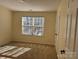 A bright bedroom with neutral walls, carpet flooring, and a large window at 1043 Boxelder Ln, Charlotte, NC 28262