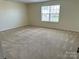 Bright, carpeted bedroom with a large window and neutral wall paint at 1043 Boxelder Ln, Charlotte, NC 28262