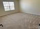 Bright carpeted bedroom featuring neutral walls and a large window at 1043 Boxelder Ln, Charlotte, NC 28262