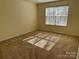 Bedroom featuring neutral carpet, walls and a window with shade blinds at 1043 Boxelder Ln, Charlotte, NC 28262