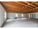 Spacious unfinished basement with exposed wooden beams and concrete floor at 107 S Myrtle Ave, China Grove, NC 28023