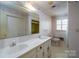 Spacious bathroom featuring double sinks and a shower with patterned wallpaper at 107 S Myrtle Ave, China Grove, NC 28023