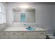 Traditional bathroom with striped wallpaper, blue sink, and white cabinets at 107 S Myrtle Ave, China Grove, NC 28023