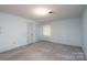 Empty light blue bedroom with two doors, window, and overhead lighting at 107 S Myrtle Ave, China Grove, NC 28023