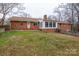 Back of home showing a brick exterior, sunroom, back door, and spacious yard at 107 S Myrtle Ave, China Grove, NC 28023