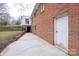 Exterior side of home showing a brick exterior, back door, and entrance to lower level at 107 S Myrtle Ave, China Grove, NC 28023