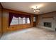 Cozy living room with wood paneled walls, fireplace, carpet and large windows at 107 S Myrtle Ave, China Grove, NC 28023