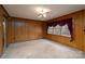 Bright and airy living room featuring carpet, wood paneled walls and classic chandelier at 107 S Myrtle Ave, China Grove, NC 28023