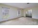 Inviting living room with neutral carpet, light walls and windows offering views of the outdoors at 107 S Myrtle Ave, China Grove, NC 28023