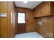 Mud room with wood paneled walls, white tile floor and door to the outside at 107 S Myrtle Ave, China Grove, NC 28023