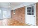 Sunroom with red brick accent wall, terra cotta tile floor and white ceiling fan at 107 S Myrtle Ave, China Grove, NC 28023