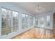 Bright sunroom with lots of windows, white ceiling fan, and terra cotta tile floor at 107 S Myrtle Ave, China Grove, NC 28023