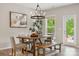 Chic dining area with modern chandelier, wooden table and bench seating, bathed in natural light at 1082 Dorsey Dr, Fort Mill, SC 29715