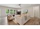 Sunlit living room with a cozy stone fireplace, neutral decor, and views of the outdoor living space at 1082 Dorsey Dr, Fort Mill, SC 29715
