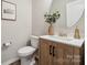 Stylish powder room with a wood vanity, modern fixtures, and a decorative mirror at 1082 Dorsey Dr, Fort Mill, SC 29715