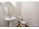 Half bathroom featuring a pedestal sink and modern fixtures, and wood-look flooring at 11029 Ardglass Ct, Charlotte, NC 28213