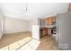 Open-concept kitchen and living area with stainless steel appliances and wood-look flooring at 11029 Ardglass Ct, Charlotte, NC 28213