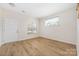 Bright living room features beautiful laminate floors, a large window, and neutral walls creating an open space at 11029 Ardglass Ct, Charlotte, NC 28213