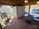 Outdoor deck with covered seating area including a rocking chair and fire pit table at 114 Dove Ln, New London, NC 28127