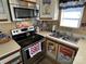 Step into this vintage kitchen, complete with modern microwave, stainless steel stove, and a double sink with playful accents at 117 Badin Lake Cir, New London, NC 28127