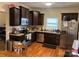 Well-lit kitchen featuring stainless steel appliances, wooden floors and dark wood cabinetry at 1301 N Mcdowell St, Charlotte, NC 28205