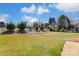 Landscaped backyard with a spacious lawn, a charming wooden fence, and mature trees at 1362 Copper Creek Ln, Fort Mill, SC 29715