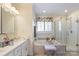 Primary bathroom featuring dual vanity sinks, soaking tub and separate glass shower at 16032 Hollingbourne Rd, Huntersville, NC 28078