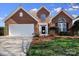Charming brick home with a well-manicured lawn and a two-car garage offers great curb appeal at 16032 Hollingbourne Rd, Huntersville, NC 28078