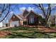 Beautiful brick home with mature trees, lush green lawn, and a two-car garage for ample parking at 16032 Hollingbourne Rd, Huntersville, NC 28078