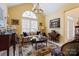 Cozy living room featuring a vaulted ceiling, plush seating, and large window for natural light at 16032 Hollingbourne Rd, Huntersville, NC 28078