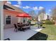 Backyard patio with table, chairs, umbrella, and grill offers a perfect spot for outdoor relaxation and entertaining at 16032 Hollingbourne Rd, Huntersville, NC 28078