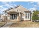 Front view of a cozy home, highlighting the covered entrance with stone accents, a small side window, and charming curb appeal at 1720 Dewberry Pl, Salisbury, NC 28146