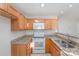 Kitchen boasts wooden cabinets, stainless steel appliances, granite countertops, and tile floor at 1720 Dewberry Pl, Salisbury, NC 28146