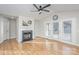 Bright living room with a fireplace, ceiling fan, and french doors, complemented by light wood flooring at 1720 Dewberry Pl, Salisbury, NC 28146
