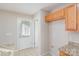 Pantry features upper wood cabinets, granite countertops, and a white door at 1720 Dewberry Pl, Salisbury, NC 28146