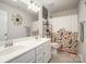 Bright bathroom featuring double sinks, floral shower curtain, and a decorative mirror at 205 Falls Cove Dr, Troutman, NC 28166