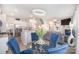 Open-concept dining area features a modern chandelier, glass table, and blue chairs at 205 Falls Cove Dr, Troutman, NC 28166