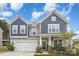 Charming two-story home with blue and gray accents, landscaped yard, and welcoming front porch at 205 Falls Cove Dr, Troutman, NC 28166